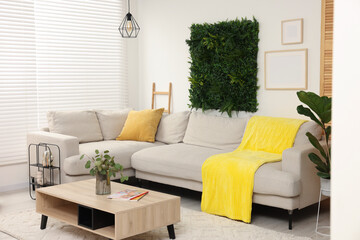Poster - green artificial plant wall panel and comfortable furniture in cozy living room. interior design