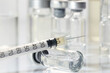 © New Africa - Glass vial and syringe with medication on white table, closeup