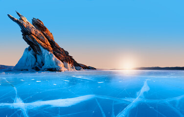 Wall Mural - Ogoy island on winter Baikal lake with transparent cracked blue ice at sunrise - Baikal, Siberia, Russia