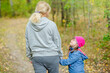© Ermolaev Alexandr - Mother and little girl with special needs walks at autumn park
