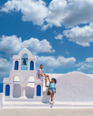 Wall Mural - A couple visit Santorini Greece, men and women visit the whitewashed Greek village of Oia during summer vacation summer holidays in Europe