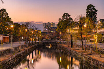 Kurashiki Bikan Historical Quarter in dusk. Townscape known for characteristically Japanese white walls of residences and willow trees lining banks of Kurashiki River. Okayama Prefecture, Japan