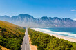 © Fokke Baarssen - Kogelbay Beach Western Cape South Africa, Kogelbay Rugged Coast Line with spectacular mountain road. Garden Route. couple of men and women walking on the road, drone aerial view