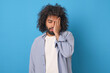 © antianti - Young tired ethnic Arabian man covers face with palm feeling loss of strength and lack of opportunity for further action due to problems in personal life stands posing in blue studio.