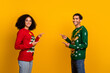 © deagreez - Photo of sweet cheerful lady guy wear new year ugly print sweaters pointing empty space isolated yellow color background
