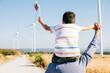 © sorapop - Father smiles carrying daughter with pinwheel. Family joy near windmills embodies global innovation in renewable energy. A bonding moment filled with happiness and community. Father Day