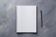 notepad and a pen on an untitled grey surface.mock up
