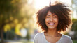 Headshot of beautiful smiling African American woman in blurred park