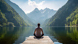 Fototapeta  - Rear view of a man doing yoga against the backdrop of a lake in the majestic mountains