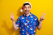 Holly jolly merry xmas party celebrate two hands v sign red hat pom pom blue shirt traditional picture isolated on yellow color background