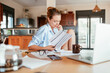 © Geber86 - Concerned young woman reading through bank statements at home