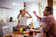 © Geber86 - Overjoyed father and little daughter make funny faces with vegetable during breakfast