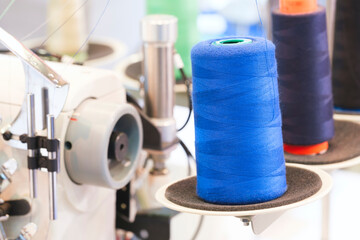 Aufkleber - Spool of thread on an industrial sewing machine in a garment factory, industrial textile background