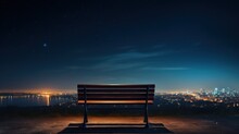  A Bench Overlooking A City At Night With A View Of The Water And The City Lights From The Top Of A Hill.