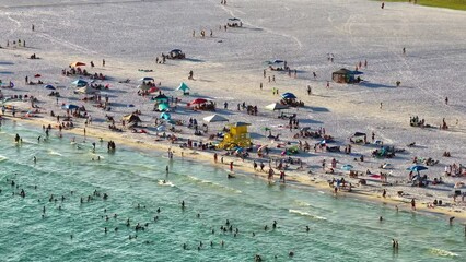 Wall Mural - View from above of evening Siesta Key beach with white sands full of tourists in Sarasota, USA. Many people enjoing vacation time swimming in Mexica gulf water and relaxing on warm Florida sun