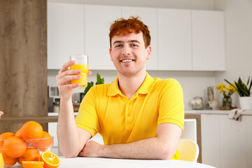 Sticker - Young man with glass of orange juice in kitchen