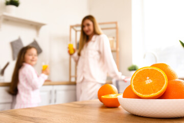 Plate with oranges on table in kitchen, closeup