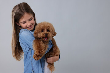 Wall Mural - Little child with cute puppy on light grey background, space for text. Lovely pet