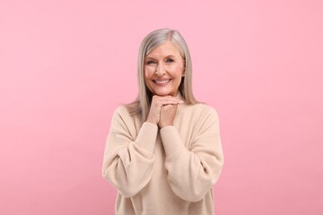 Wall Mural - Portrait of beautiful middle aged woman on pink background