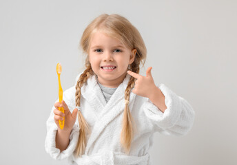 Sticker - Cute little girl pointing at toothbrush on white background