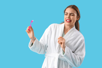 Sticker - Displeased young woman with toothbrush on blue background