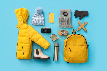 Sticker - Winter accessories with backpack on blue background, top view