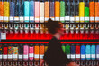 © Andrew Kornylak - A woman walks past a wall of candy dispensers, motion blurred
