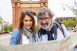 © Xavier Lorenzo - European senior tourist couple looking for location on city map. Retired mature man and woman enjoying weekend getaway in Barcelona. Elderly travelers lifestyle concept.