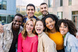 © Xavier Lorenzo - Portrait of young group of diverse people smiling at camera outdoors. Happy millennial college students enjoying time together, social gathering and hanging out at city street.