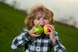 © Volodymyr - Kid dressed casual holding and apple with a smile and showing eats healthy food.