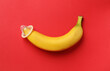 canvas print picture - Banana with condom on red background, top view. Safe sex concept
