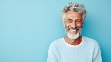 Wall Mural - Portrait of handsome bearded elderly man keeps self confident cheerful expression at camera wears formal shirt and spectacles for vision correction isolated on blue wall