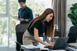 © NINENII - Business, technology and office concept - two businessmen with laptop, tablet pc computer and papers having discussion in modern office