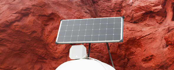 Solar cell panel with red rock space background. 