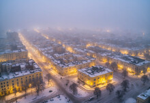 Center Of The City In Winter. At Night And Foggy. Drone Point Of View. The Light Is Yellow. Quiet Without People