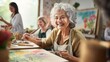 © ND STOCK - A senior woman, a smiling artist, enjoys painting activities in the studio with her friends in art class.