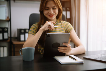 Wall Mural - Businesswoman working in the office with working notepad, tablet and laptop documents .