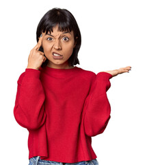 Wall Mural - Young Hispanic woman with short black hair in studio holding and showing a product on hand.