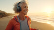 Middle age woman jogging on beach at morning with music on her headphones