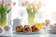 Traditional Easter hot cross buns with fresh spring tulip flowers in a bright modern kitchen.