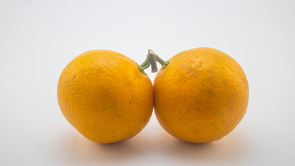 two yellow tangerines on a white background, fruit on a white background