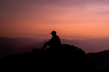 A man who hikers enjoys a break look at the top of the mountain adventure travel.