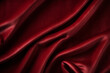 Elegant folds of a smooth deep red burgundy vinous satin velvet fabric with shadows and highlights background. Textile drapery concept