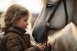 A little girl standing next to a beautiful white horse. 