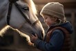 A little girl is shown petting a white horse. This image can be used to depict a child's love for animals or to illustrate the bond between humans and horses.