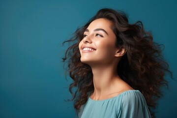 Wall Mural - Beautiful happy woman on blue background looking to the side