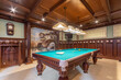 © alhim - Billiard room with classic English interior design. The ceiling and walls are decorated .with dark wood. A wall with a beautiful painting.