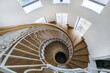 © alhim - Spiral staircase with wooden steps and white metal railings in the bright lobby of a .country house.