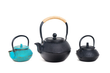 Wall Mural - Three traditional cast iron teapots on white background.