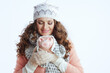© Alliance - smiling trendy female in sweater, mittens, hat and scarf